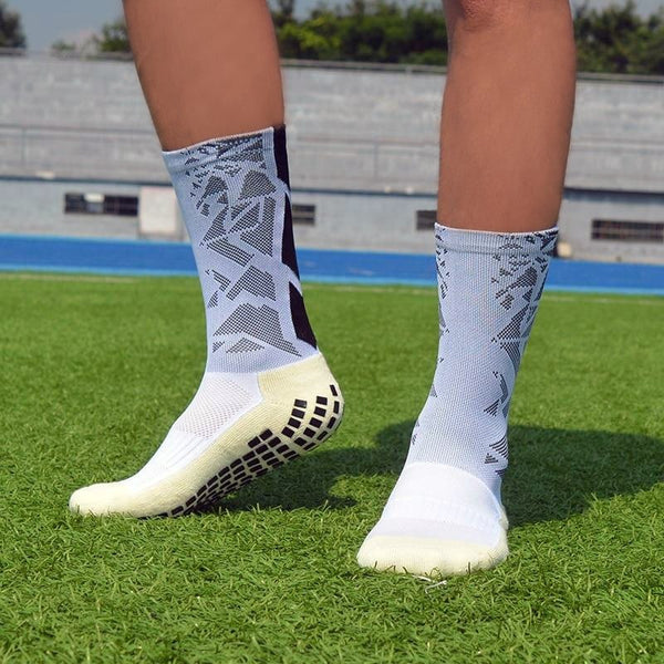 White anti-slip football grip socks worn on artificial turf pitch